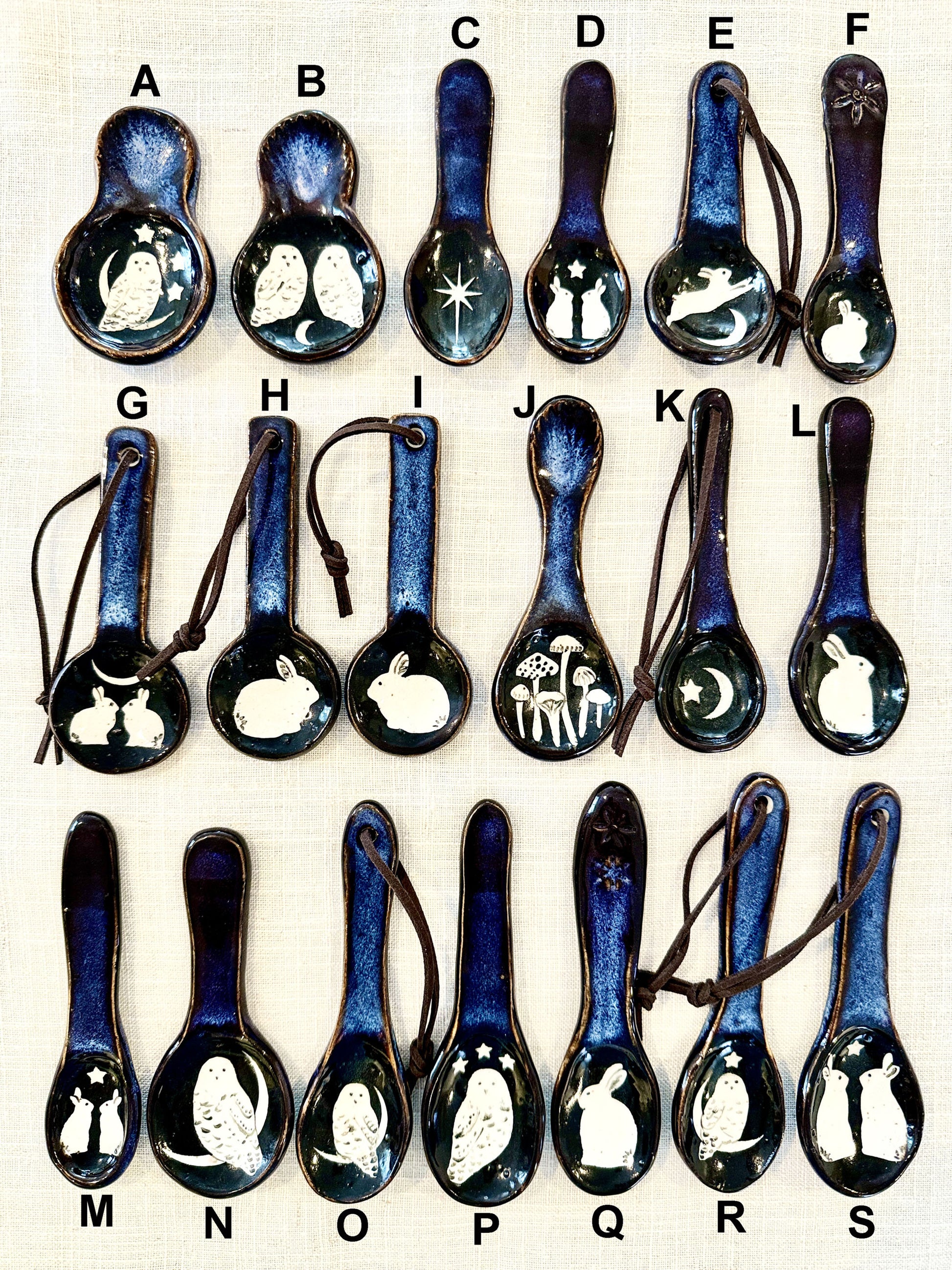 Collection of ceramic spoons with various designs on a white background